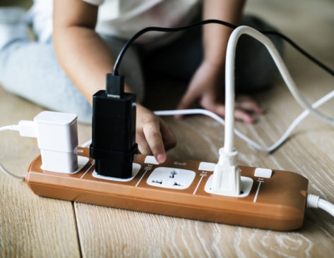 Toddler playing with dangerous electrical plug