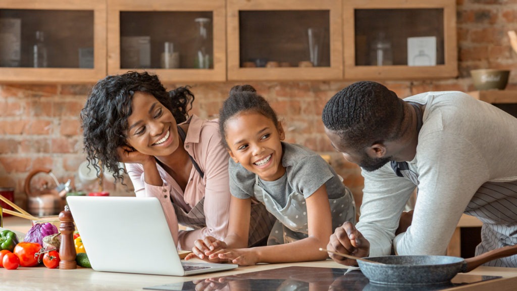 Friendly-afro-family-using-laptop-at-kitchen,-looking-for-recipe