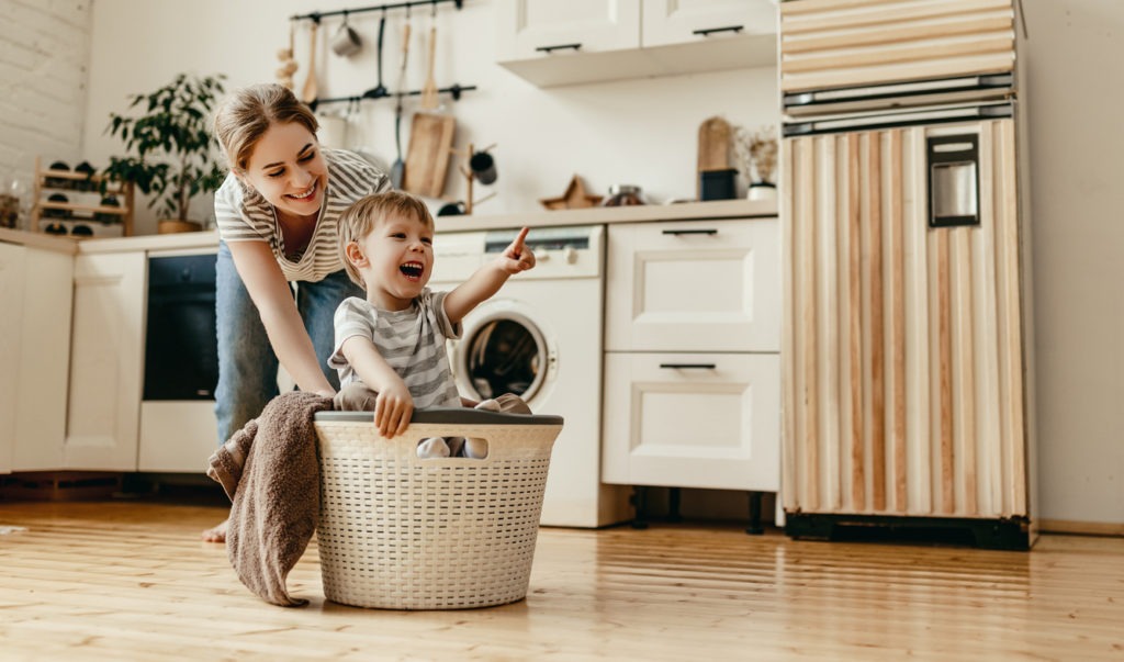 Happy family mother housewife and child son in laundry room